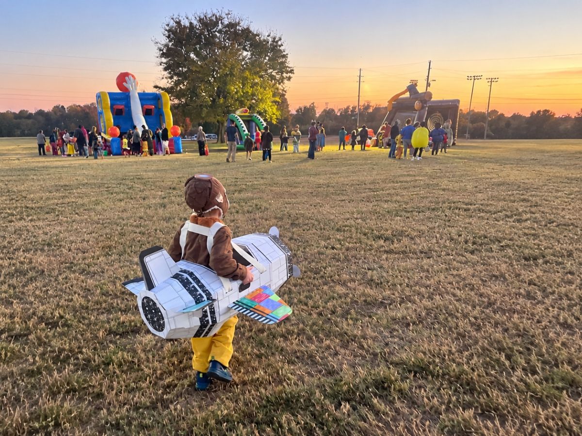 A little boy in a Halloween costume runs across a field at a trunk-or-treat event in Springfield.